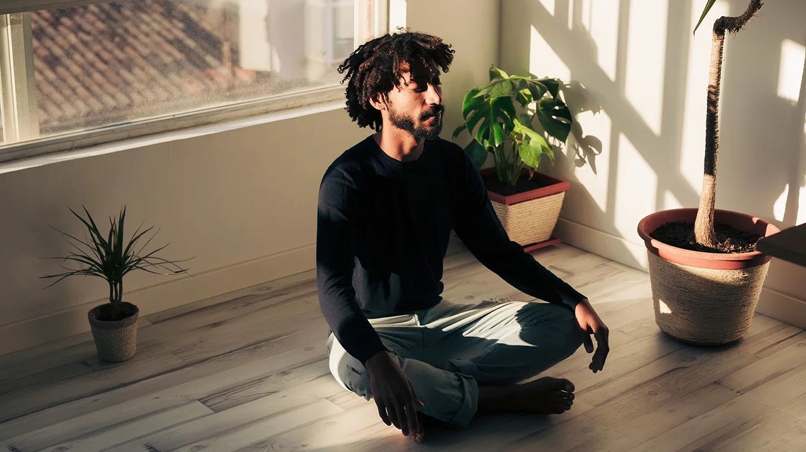 Black male sitting and meditating with eyes closed