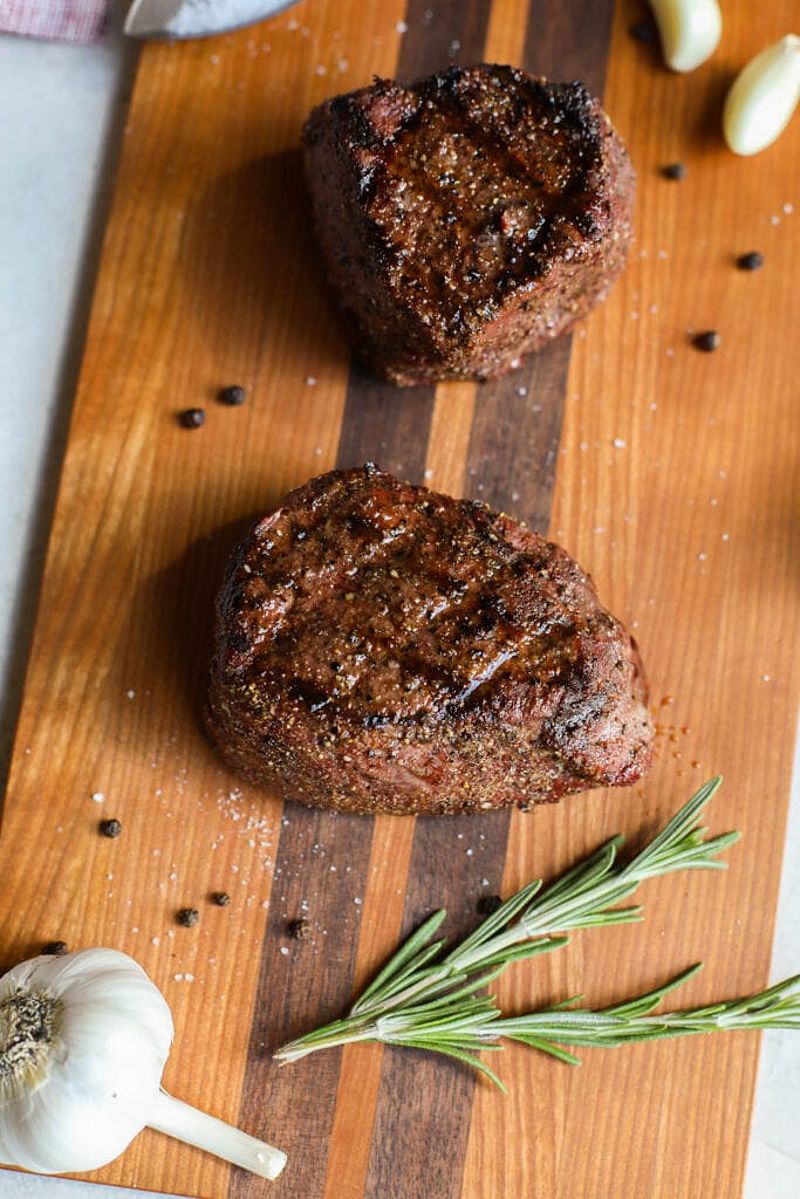 Grilled grass fed beef steaks on cutting board