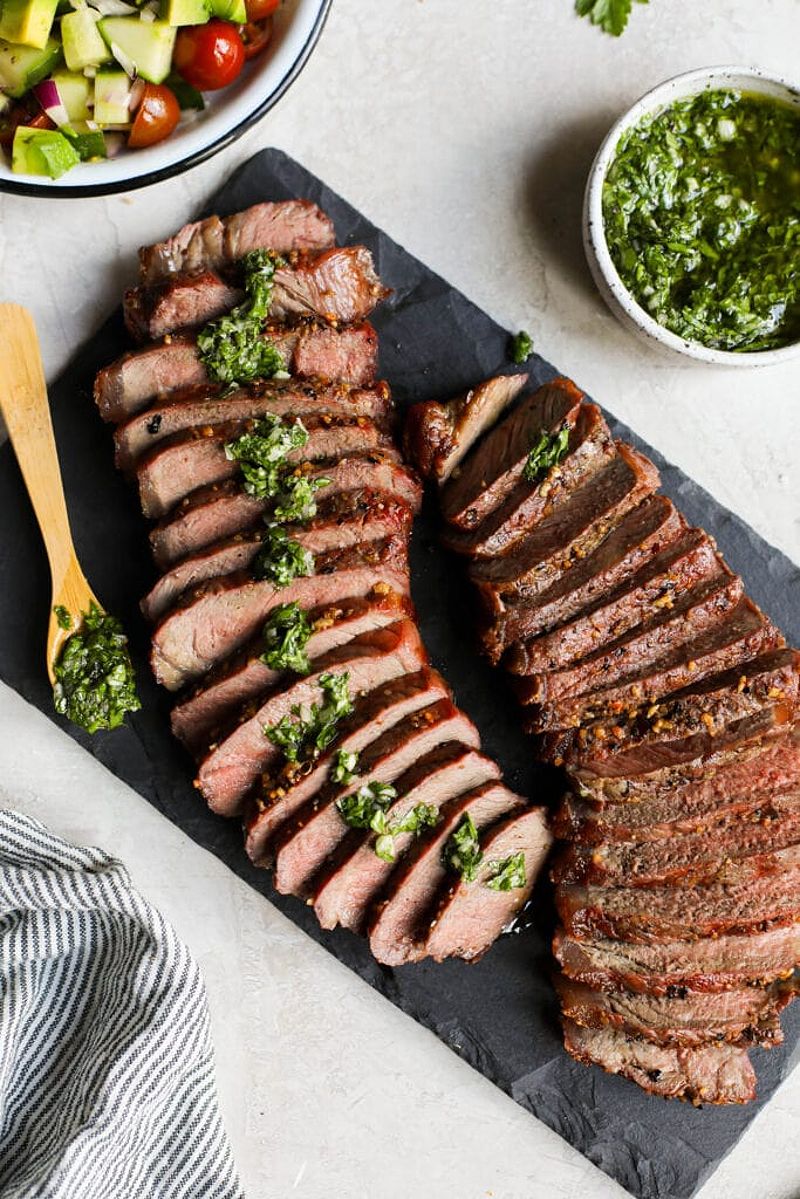 Overhead view cooked grass fed beef, sliced on cutting board